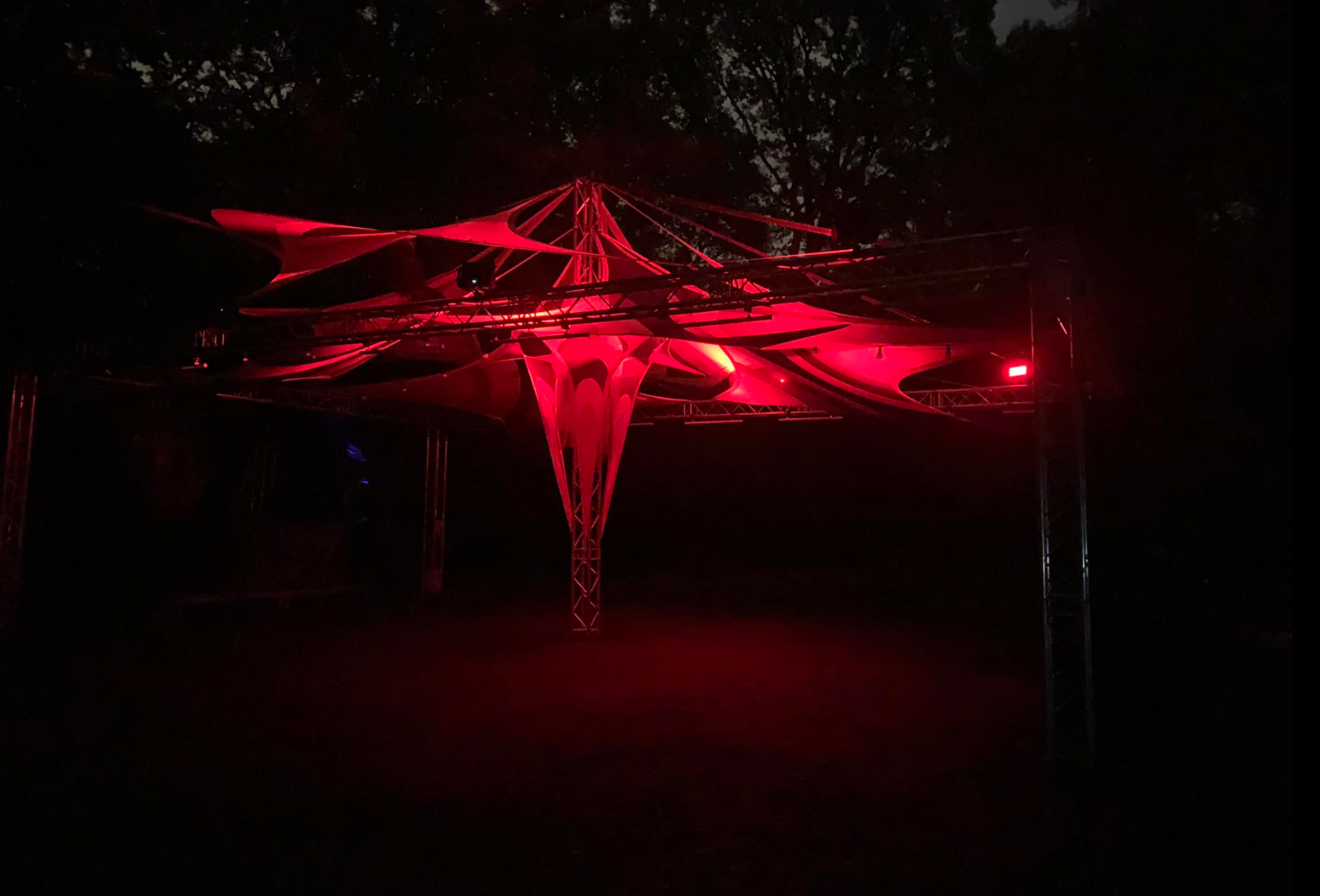Cirkustält upplyst i rött med scenljus och rök